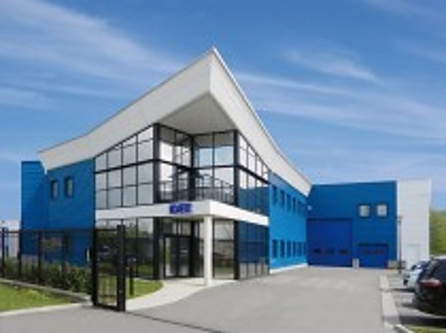 Façade d'un bâtiment d'entreprise moderne aux murs bleus et blancs, avec de grandes baies vitrées et une cour devant l'entrée.